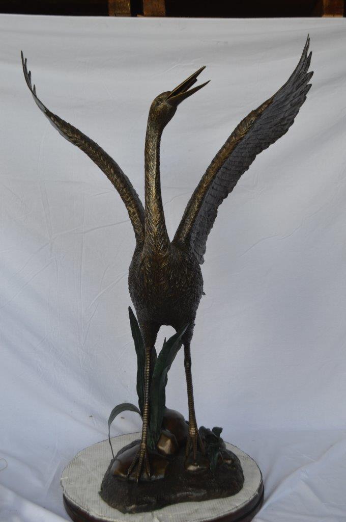 Crane standing on a stone bronze statue - Size: 28"L x 32"W x 49"H.