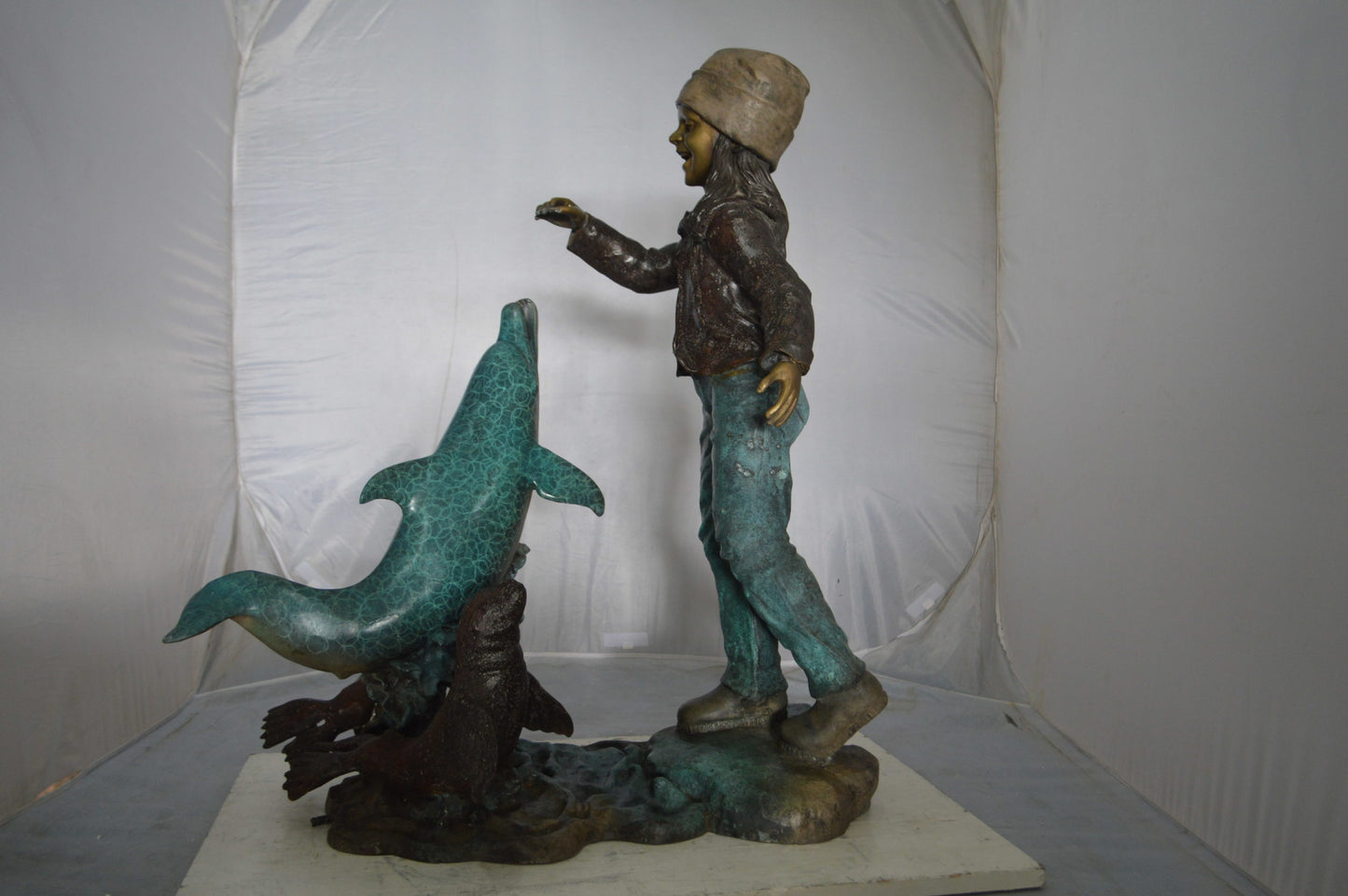 Girl feeding a dolphin and seals bronze fountain - Size: 28"L x 17"W x 37"H.