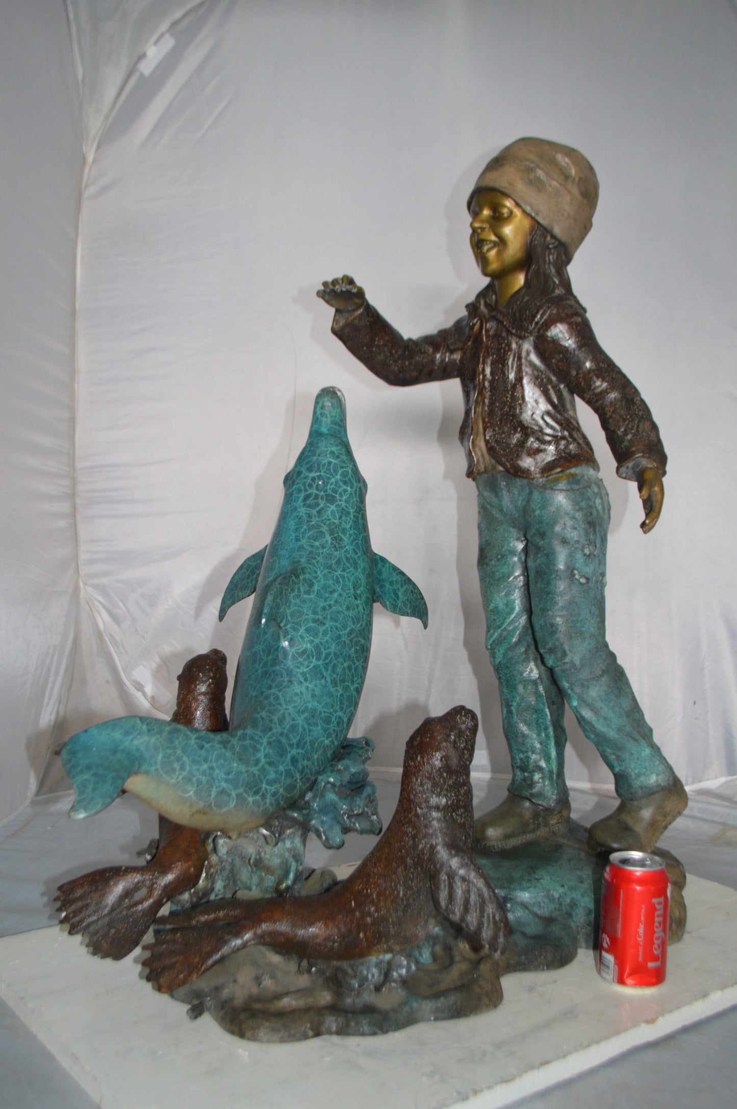 Girl feeding a dolphin and seals bronze fountain - Size: 28"L x 17"W x 37"H.