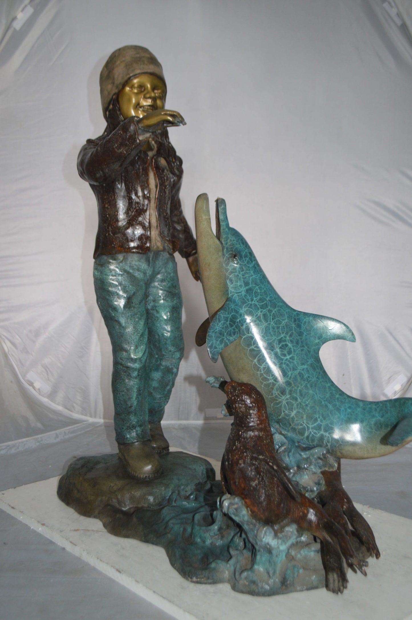 Girl feeding a dolphin and seals bronze fountain - Size: 28"L x 17"W x 37"H.