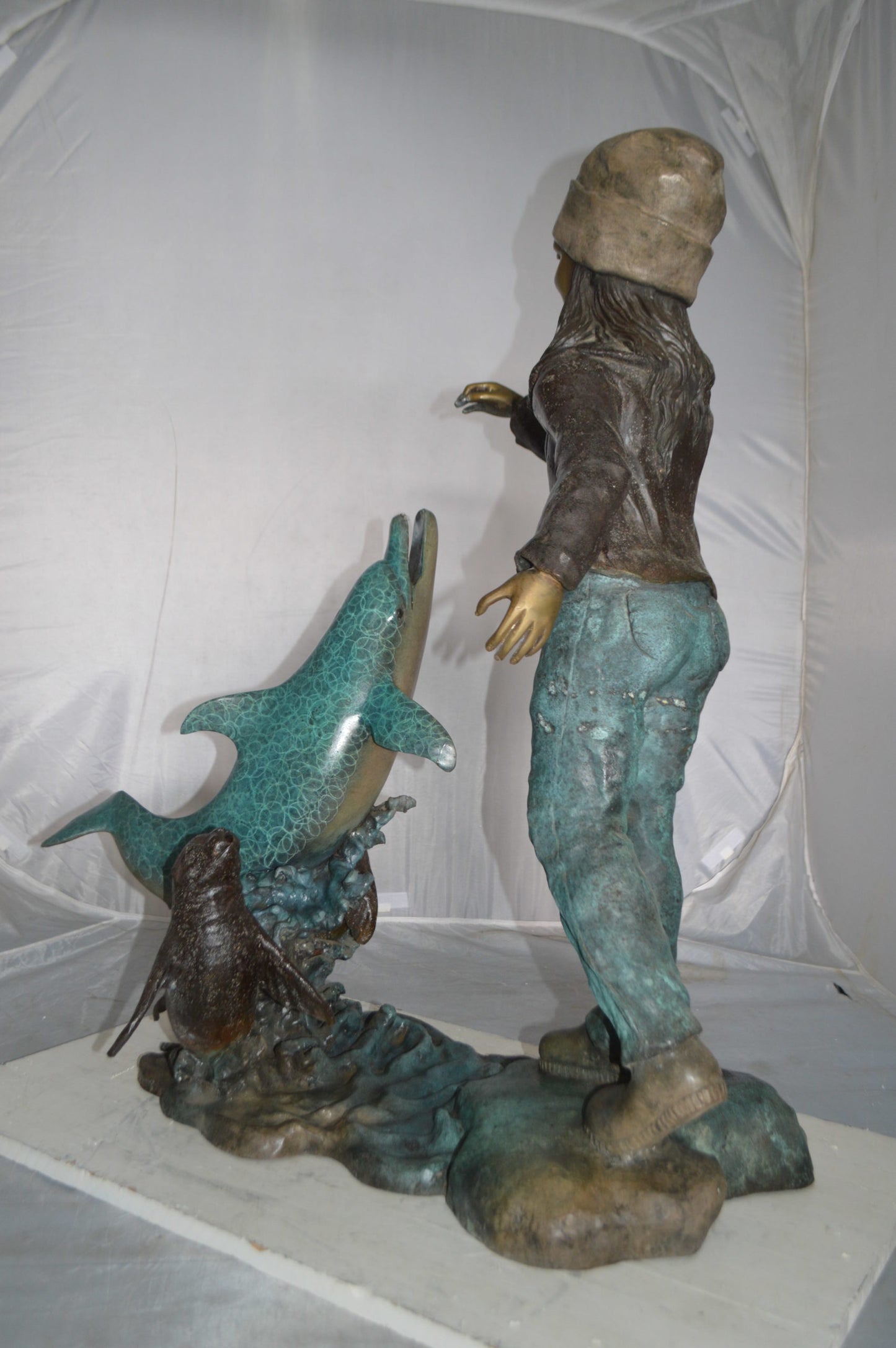 Girl feeding a dolphin and seals bronze fountain - Size: 28"L x 17"W x 37"H.