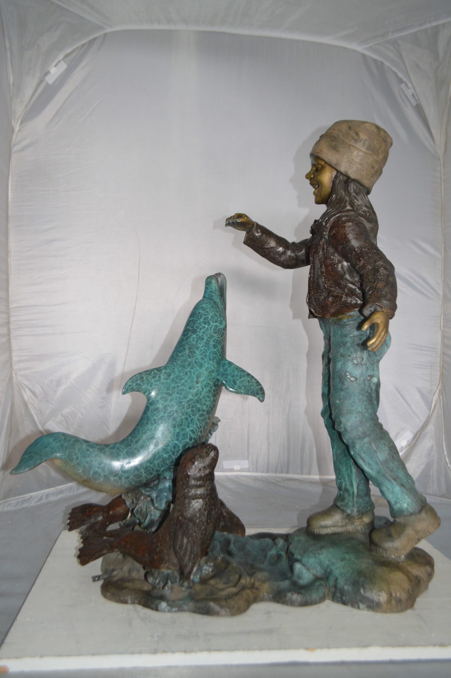 Girl feeding a dolphin and seals bronze fountain - Size: 28"L x 17"W x 37"H.