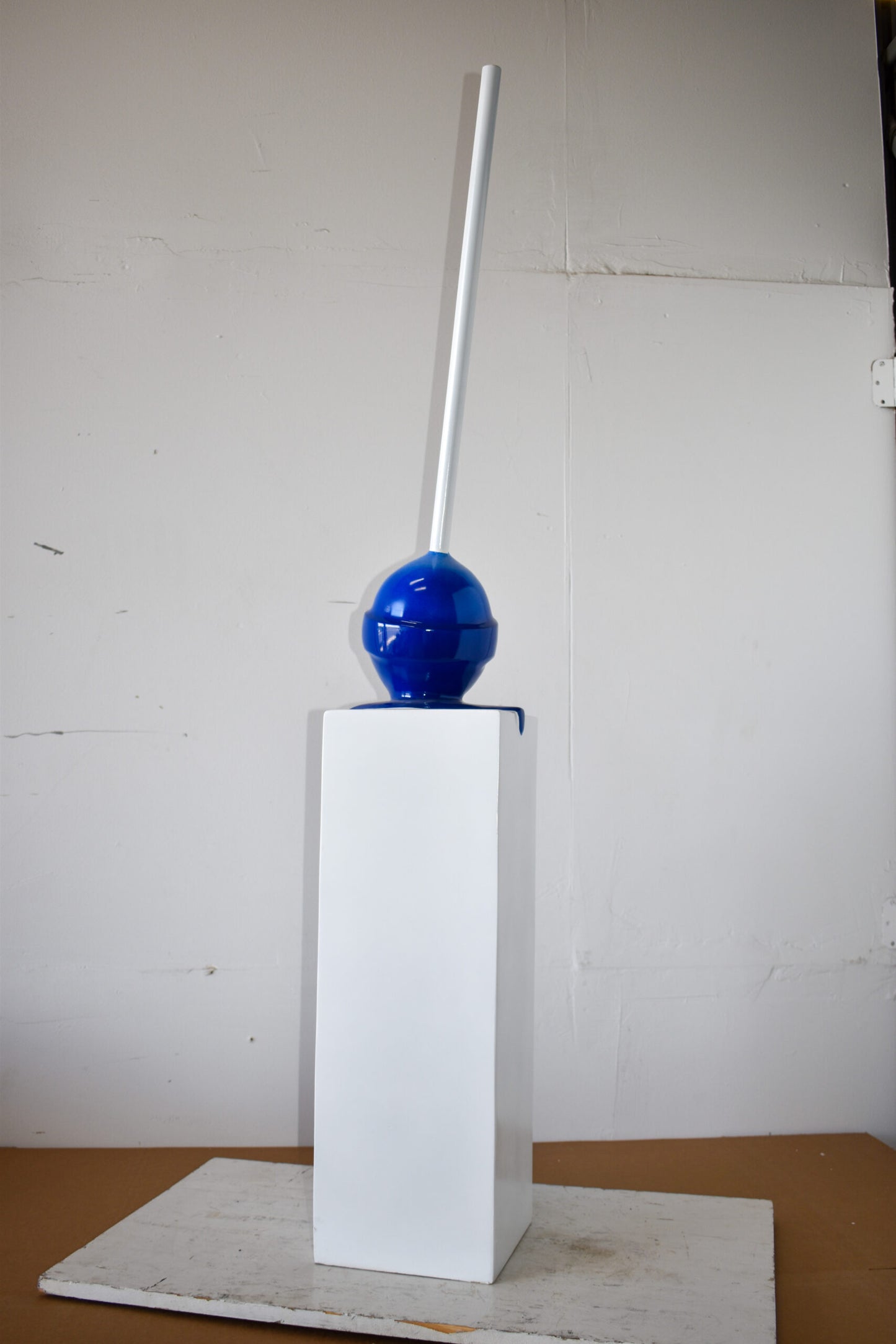 Blue Lollipop Mounted on A White Pedestal Resin Statue Size: 10" x 10" x 59"H