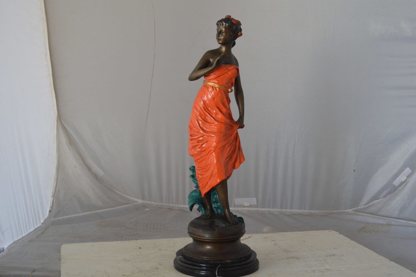 Young lady in orange bronze statue - Size: 7"L x 26"W x 25"H.