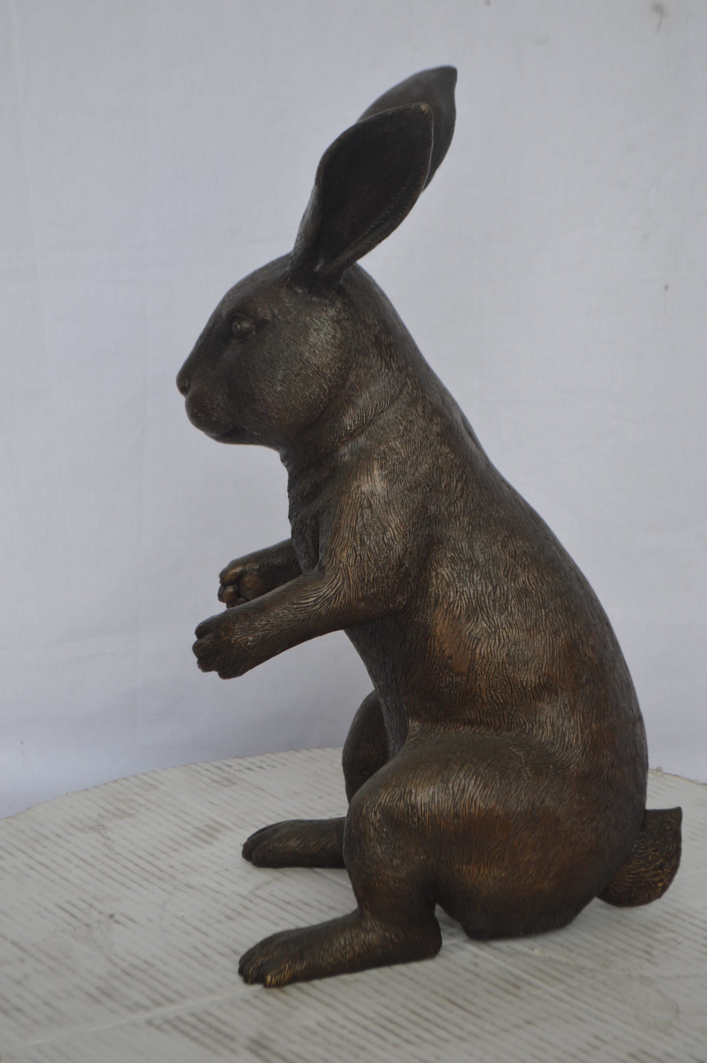 Rabbit looking down bronze statue - Size: 10"L x 12"W x 20"H.
