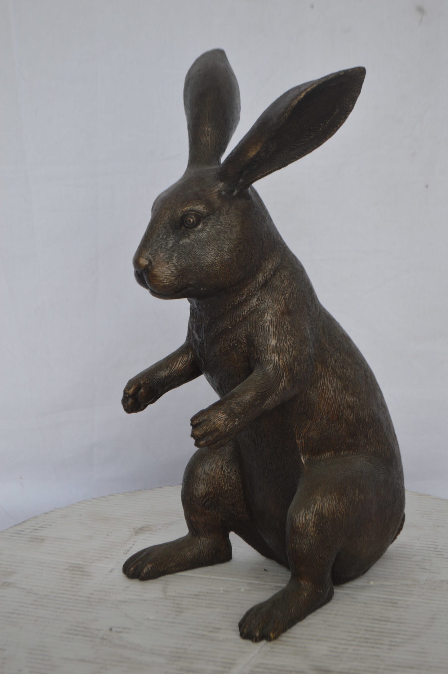 Rabbit looking down bronze statue - Size: 10"L x 12"W x 20"H.