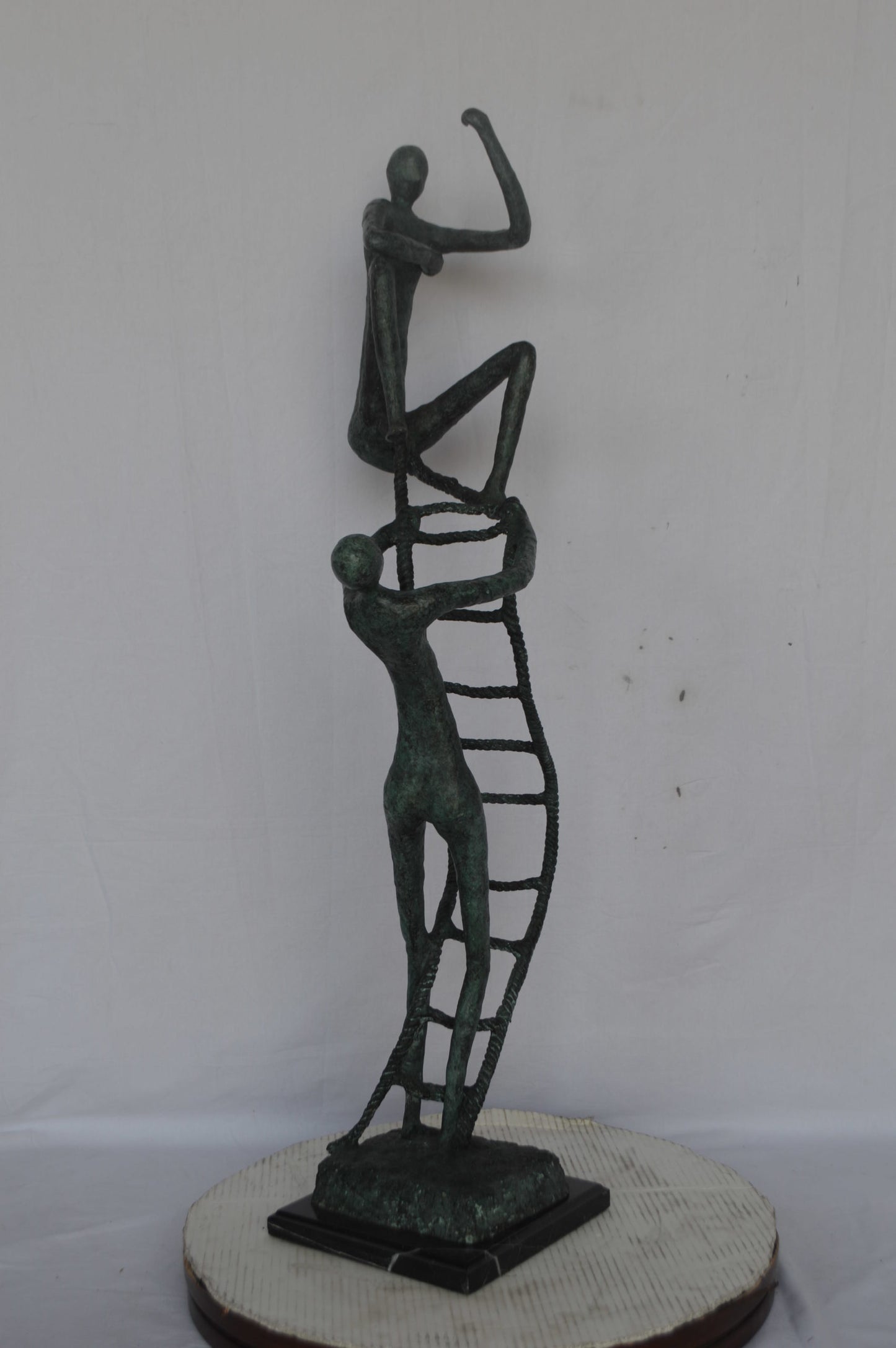 Modern art, two men climbing a latter bronze statue - Size: 14"L x 15"W x 47"H.