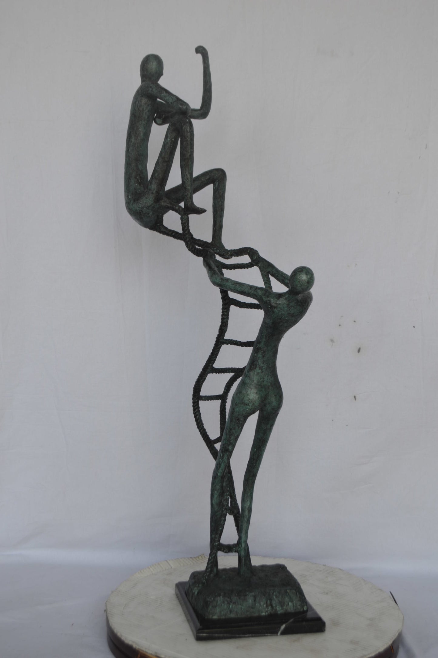 Modern art, two men climbing a latter bronze statue - Size: 14"L x 15"W x 47"H.