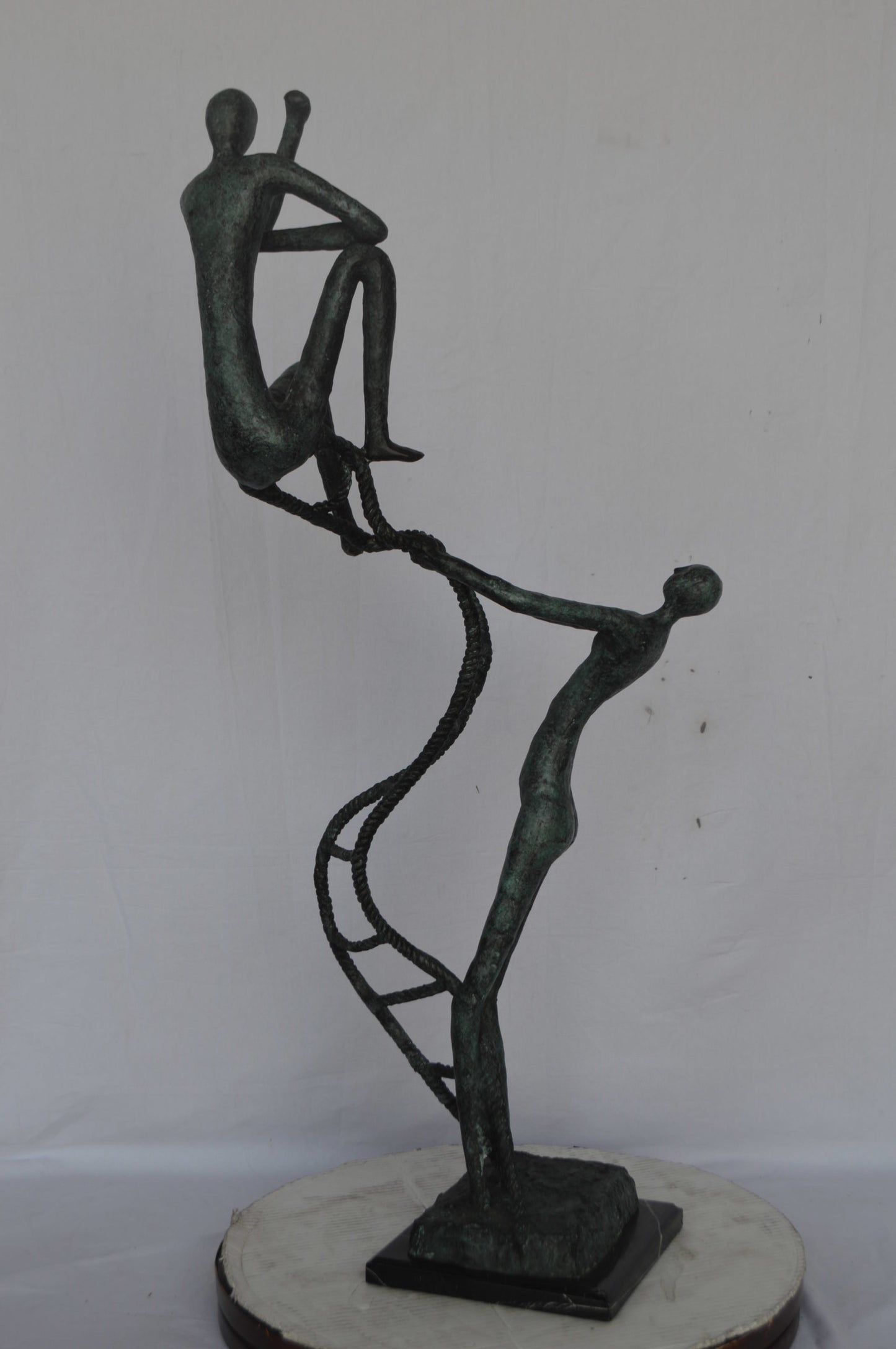 Modern art, two men climbing a latter bronze statue - Size: 14"L x 15"W x 47"H.