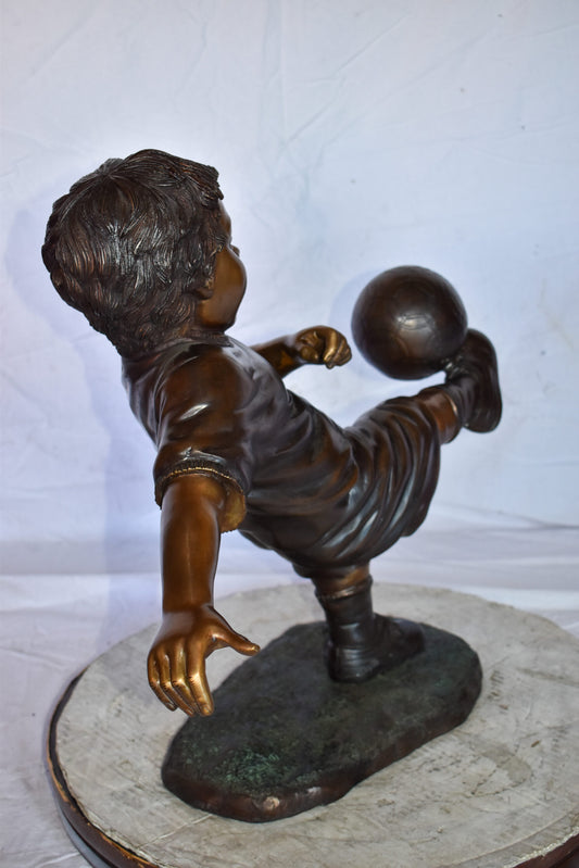 Young Boy Passionately Kicking Soccer Ball Bronze Statue  Size: 26" x 16" x 24"H