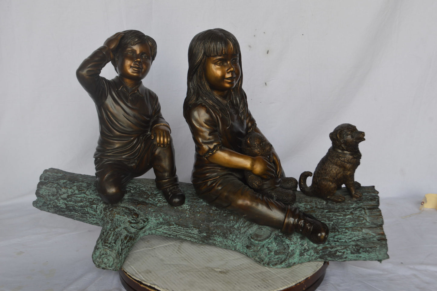 Young children and dog on a log bronze statue - Size: 40"L x 16"W x 24"H.