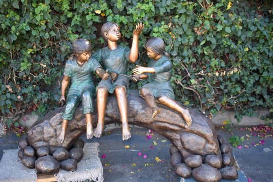 Three Kids Playing With Butterflies Bronze Statue -  Size: 70"L x 25"W x 45"H.