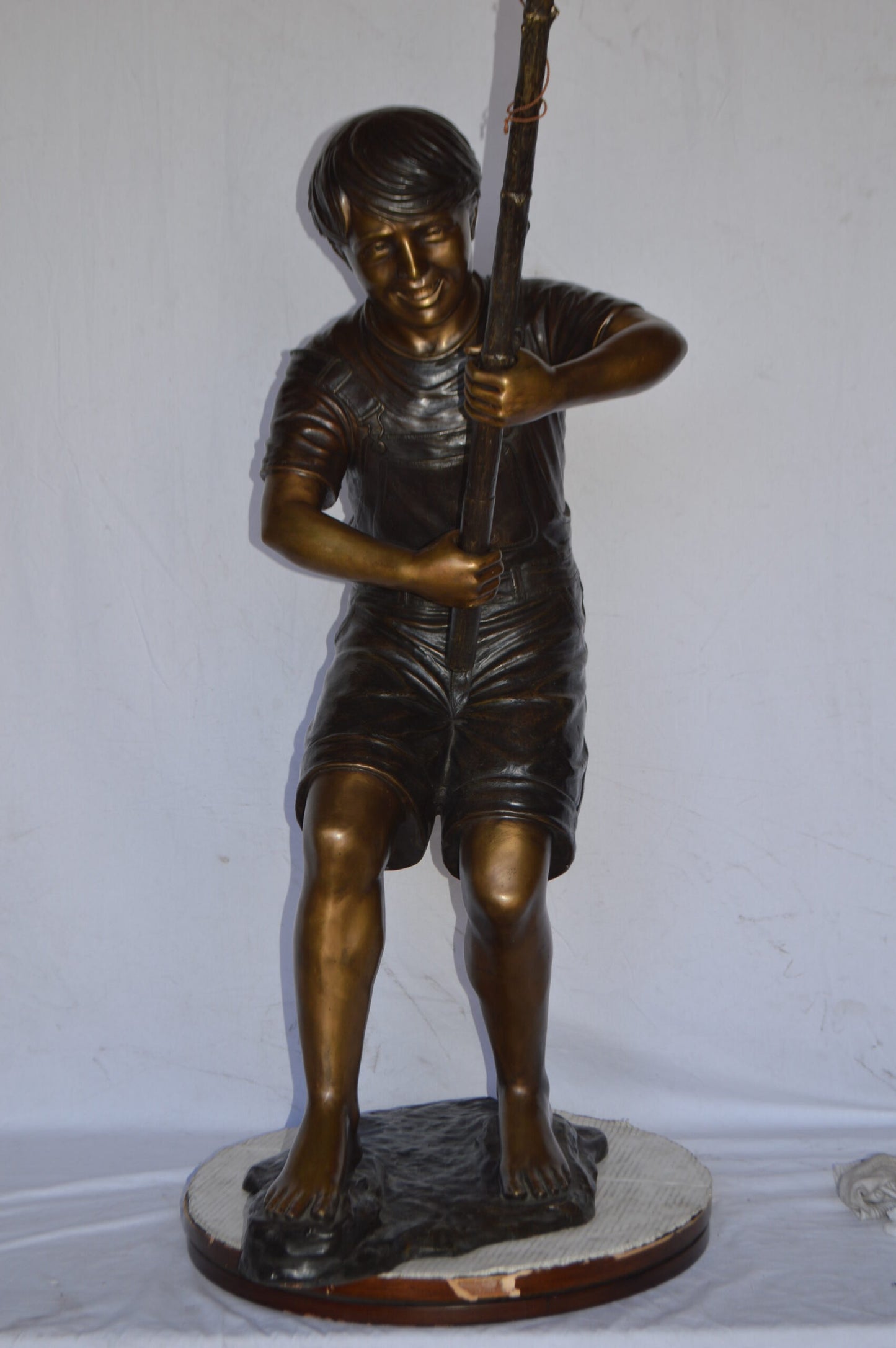 A Young Boy Fishing Bronze Statue - Size: 16"L x 54"W x 62"H.