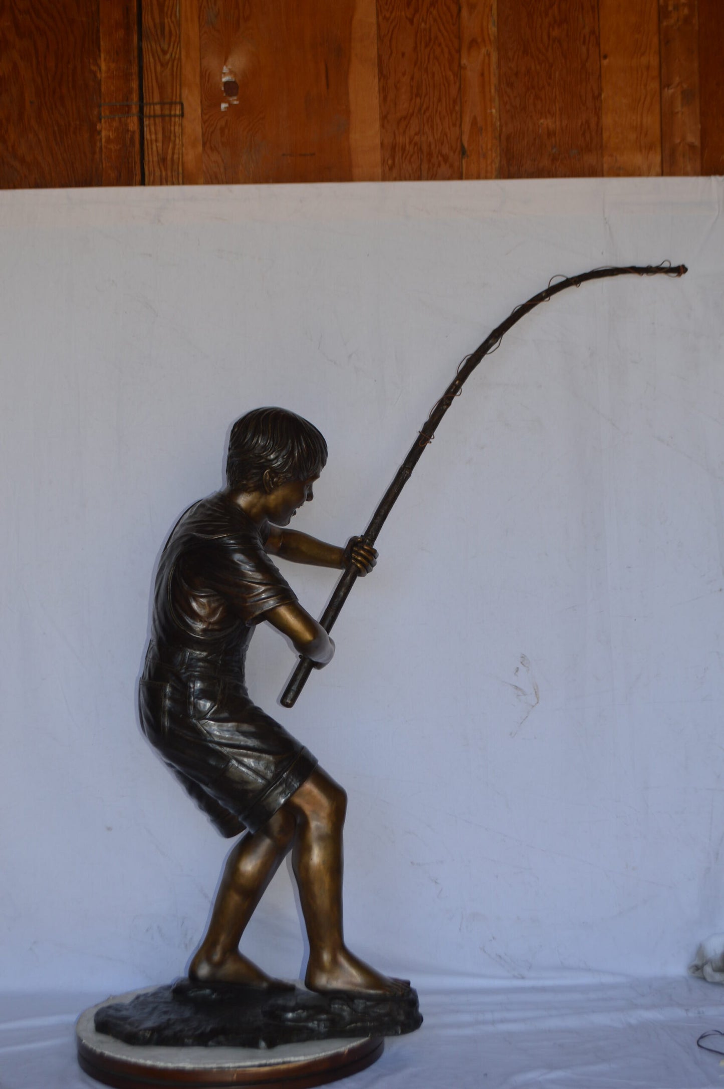 A Young Boy Fishing Bronze Statue - Size: 16"L x 54"W x 62"H.
