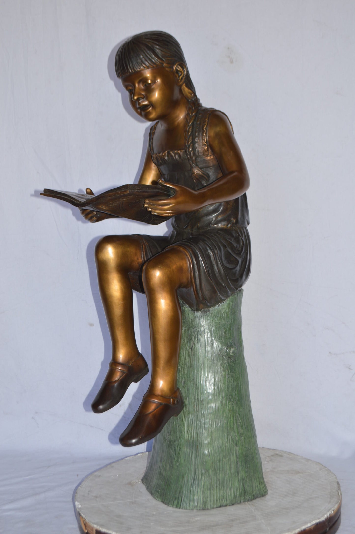 Girl Sitting on a Tree Stump, Reading Bronze Statue - Size: 15"L x 20"W x 22"H.