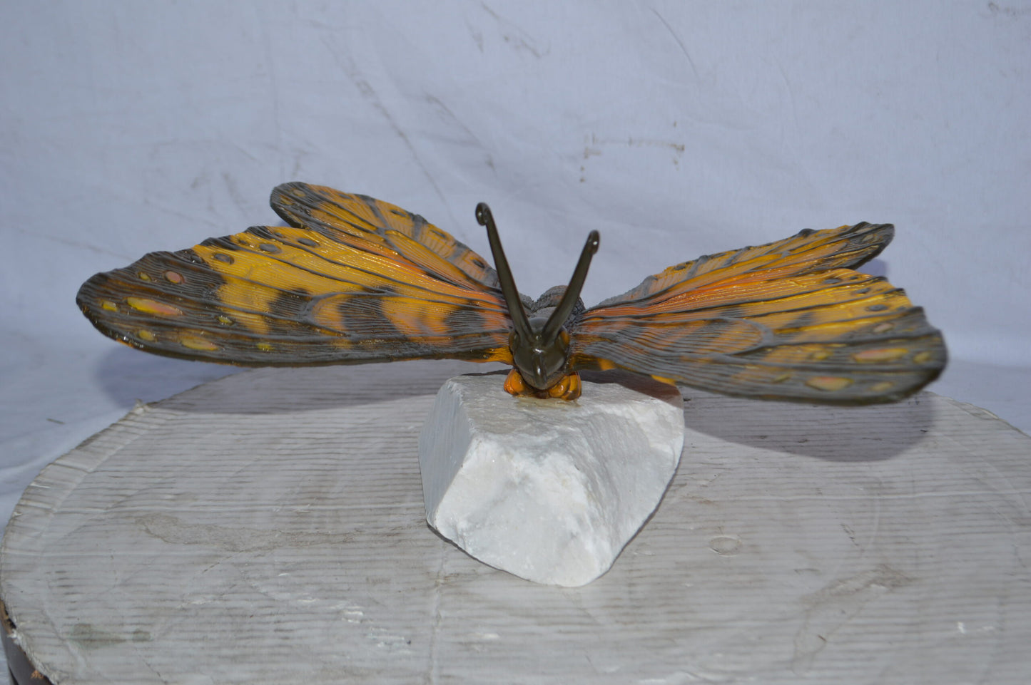 Orange Monarch butterfly bronze statue on a  rock - Size: 14"L x 16"W x 8"H.