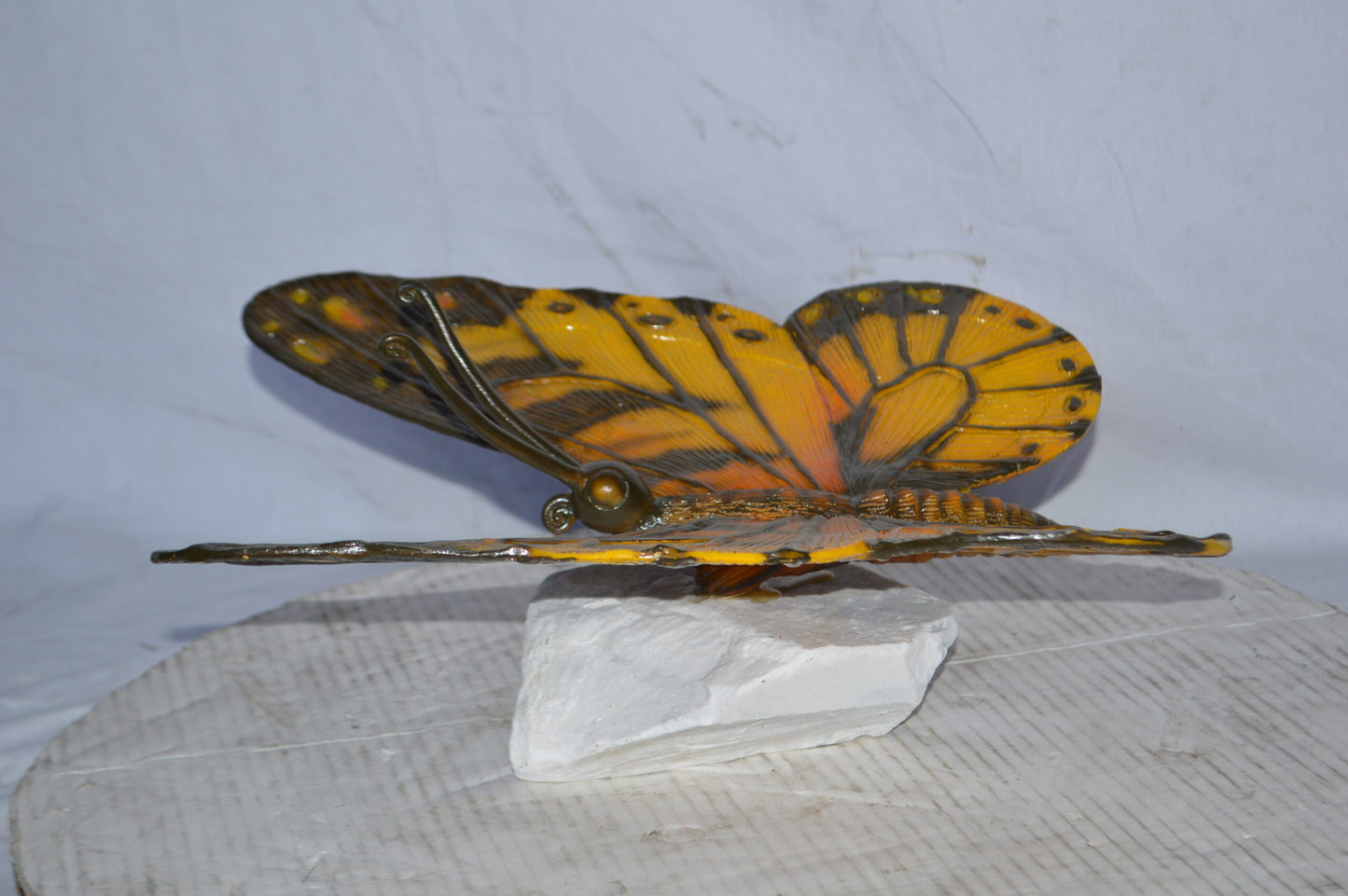 Orange Monarch butterfly bronze statue on a  rock - Size: 14"L x 16"W x 8"H.
