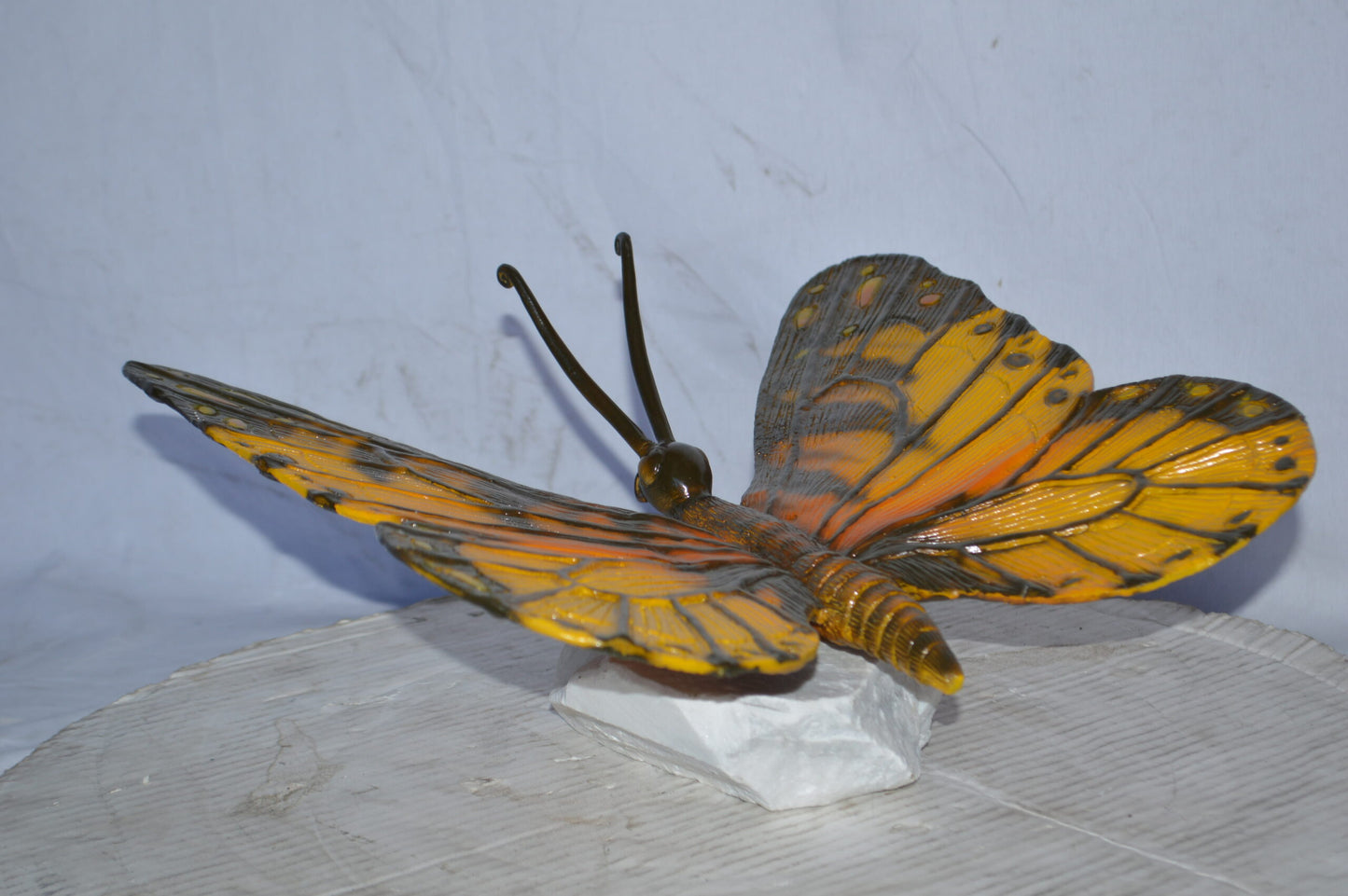 Orange Monarch butterfly bronze statue on a  rock - Size: 14"L x 16"W x 8"H.