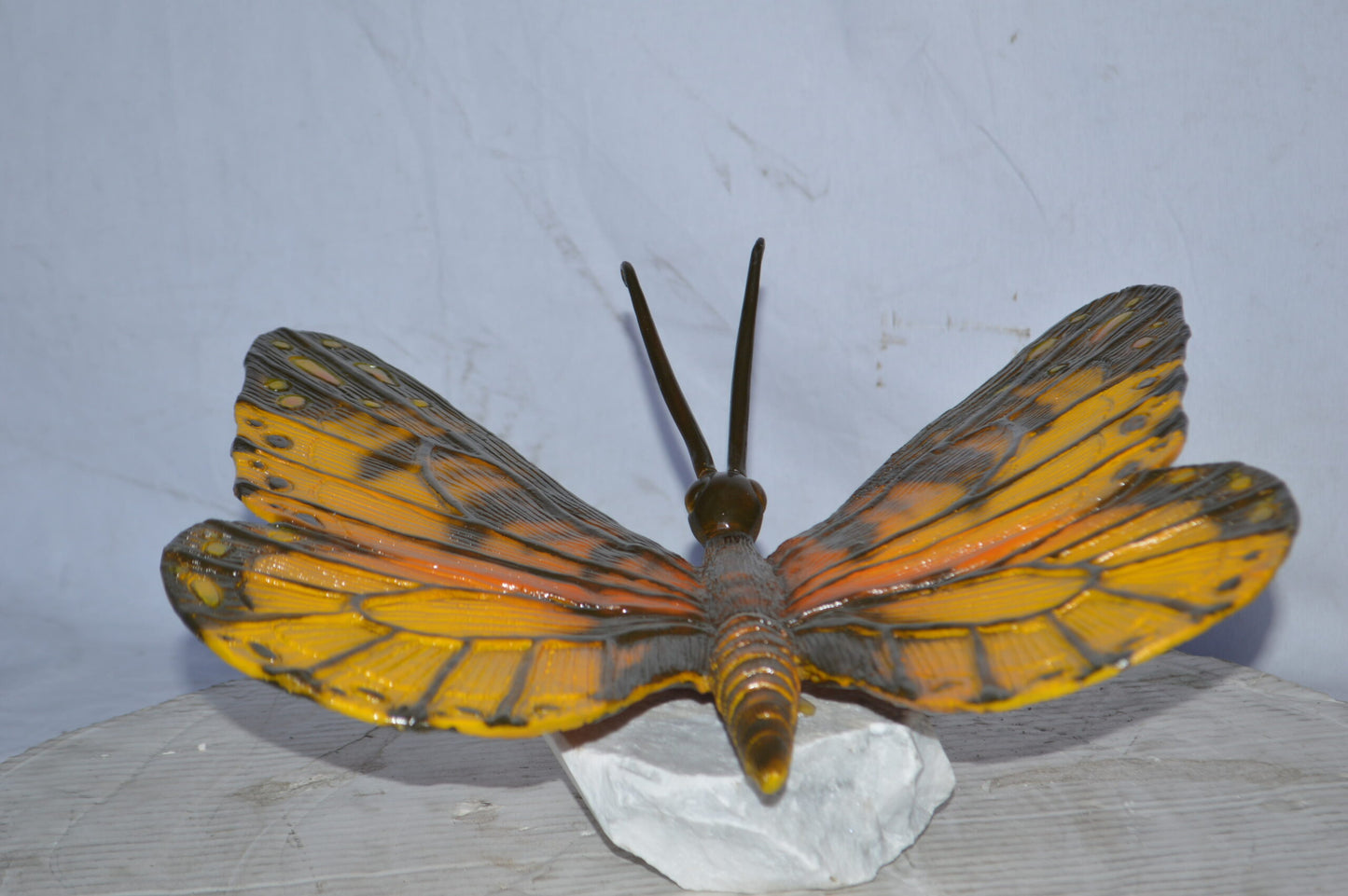 Orange Monarch butterfly bronze statue on a  rock - Size: 14"L x 16"W x 8"H.