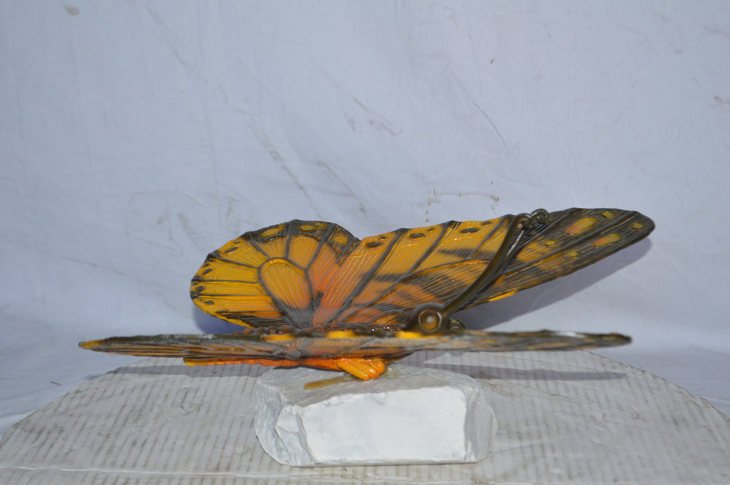 Orange Monarch butterfly bronze statue on a  rock - Size: 14"L x 16"W x 8"H.