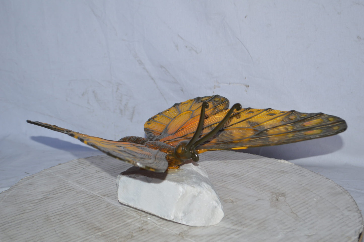 Orange Monarch butterfly bronze statue on a  rock - Size: 14"L x 16"W x 8"H.