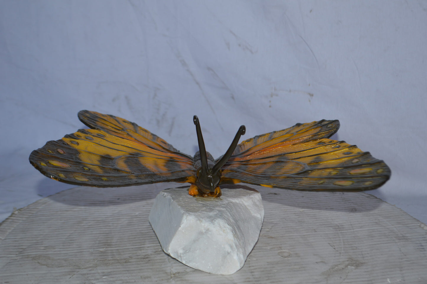 Orange Monarch butterfly bronze statue on a  rock - Size: 14"L x 16"W x 8"H.