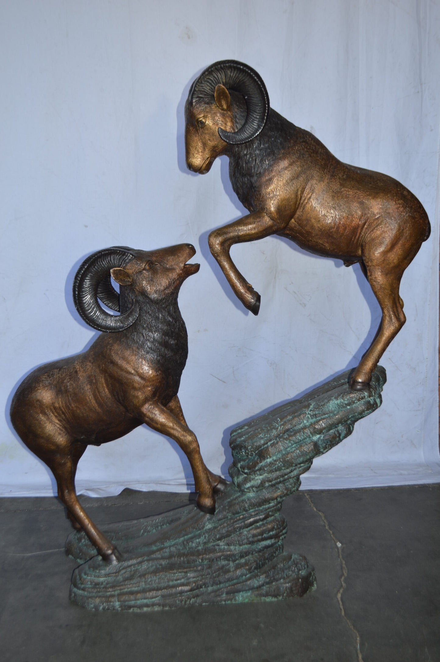 Two Life Size Rams on a rock Bronze Statue - Size: 49"L x 20"W x 64"H.