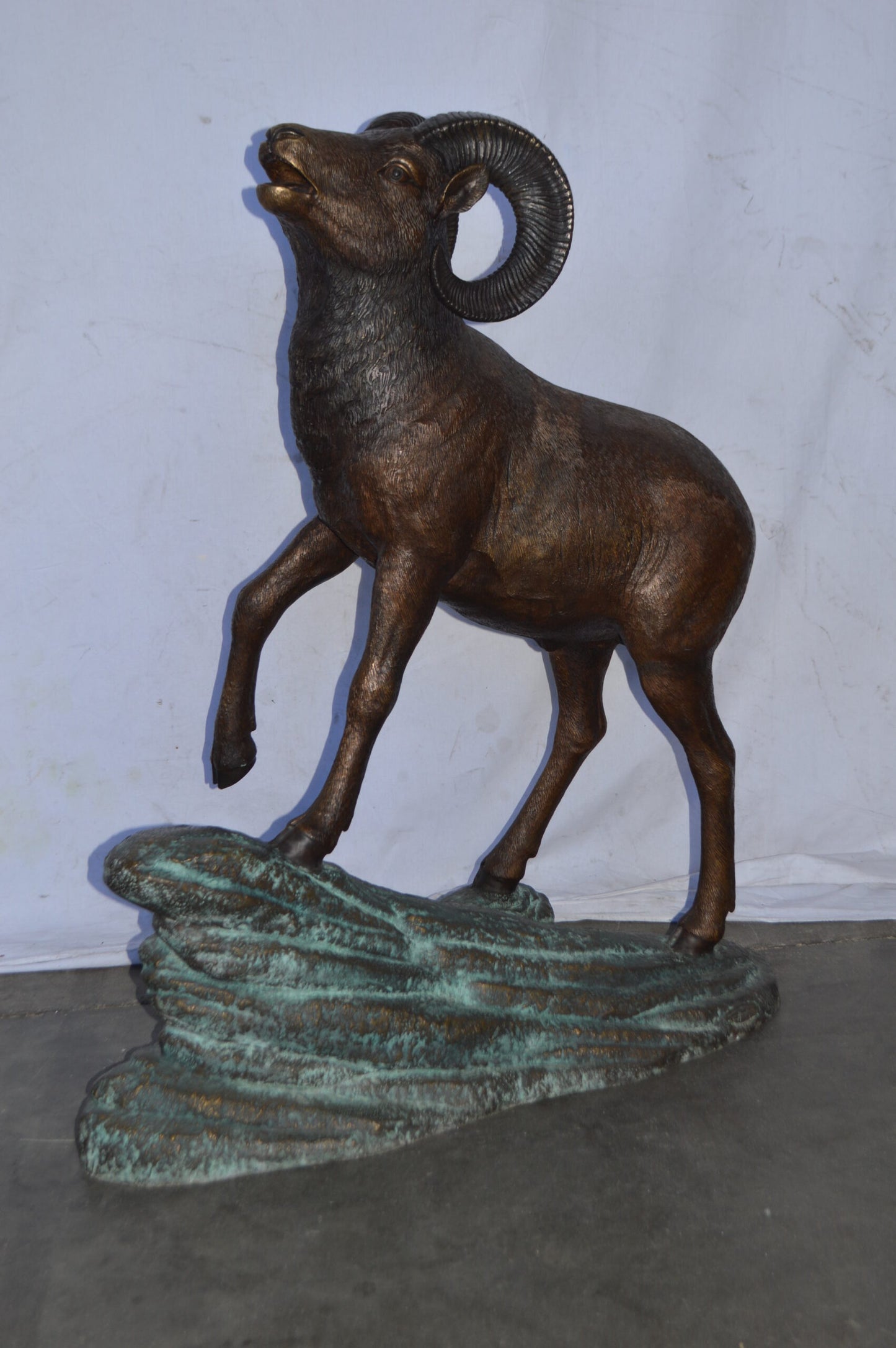 Life Size Ram standing on a rock Bronze Statue - Size: 38"L x 19"W x 45"H.