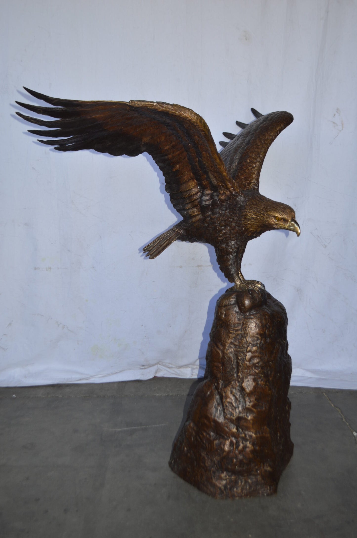 Eagle Landing on a Rock Bronze Statue - Size: 51"L x 36"W x 58"H.