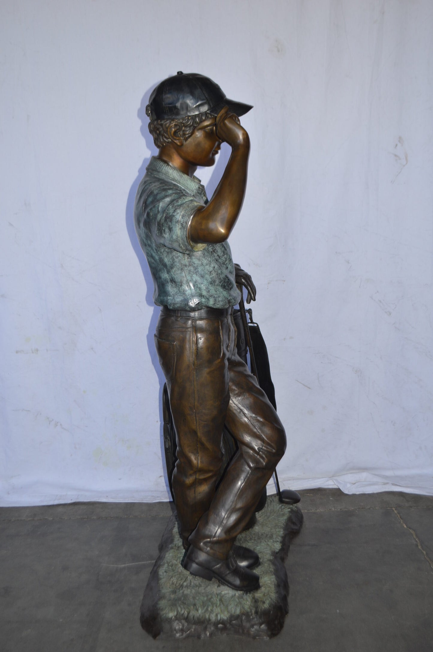 Golfer standing with his gear large bronze Statue - Size: 34"L x 21"W x 65"H.