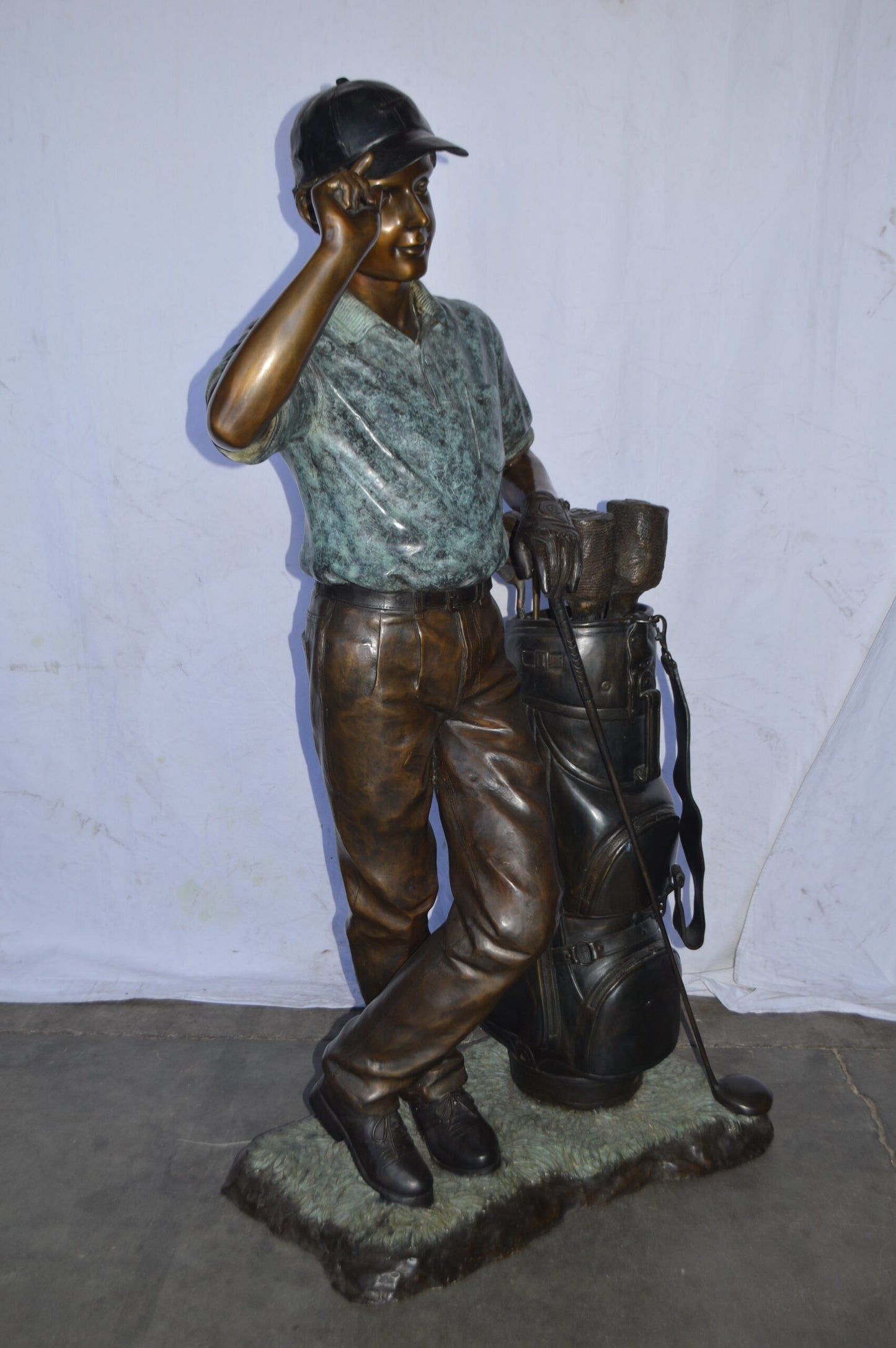Golfer standing with his gear large bronze Statue - Size: 34"L x 21"W x 65"H.
