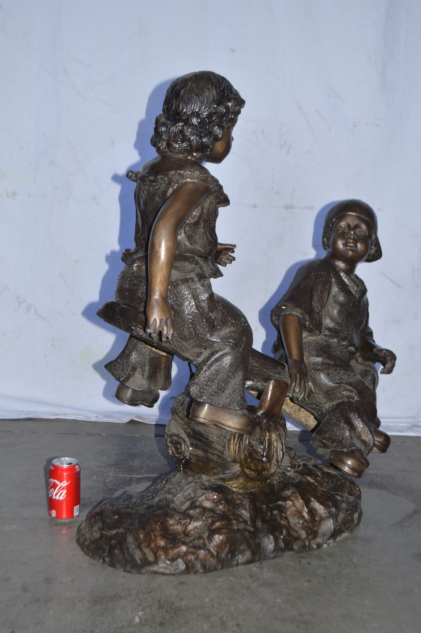 A Boy and a Girl Playing Seesaw Bronze Statue - Size: 17"L x 33"W x 36"H.
