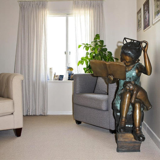 Girl sitting on a stack of books reading a book Bronze Statue - 17"x 18"x 36"H