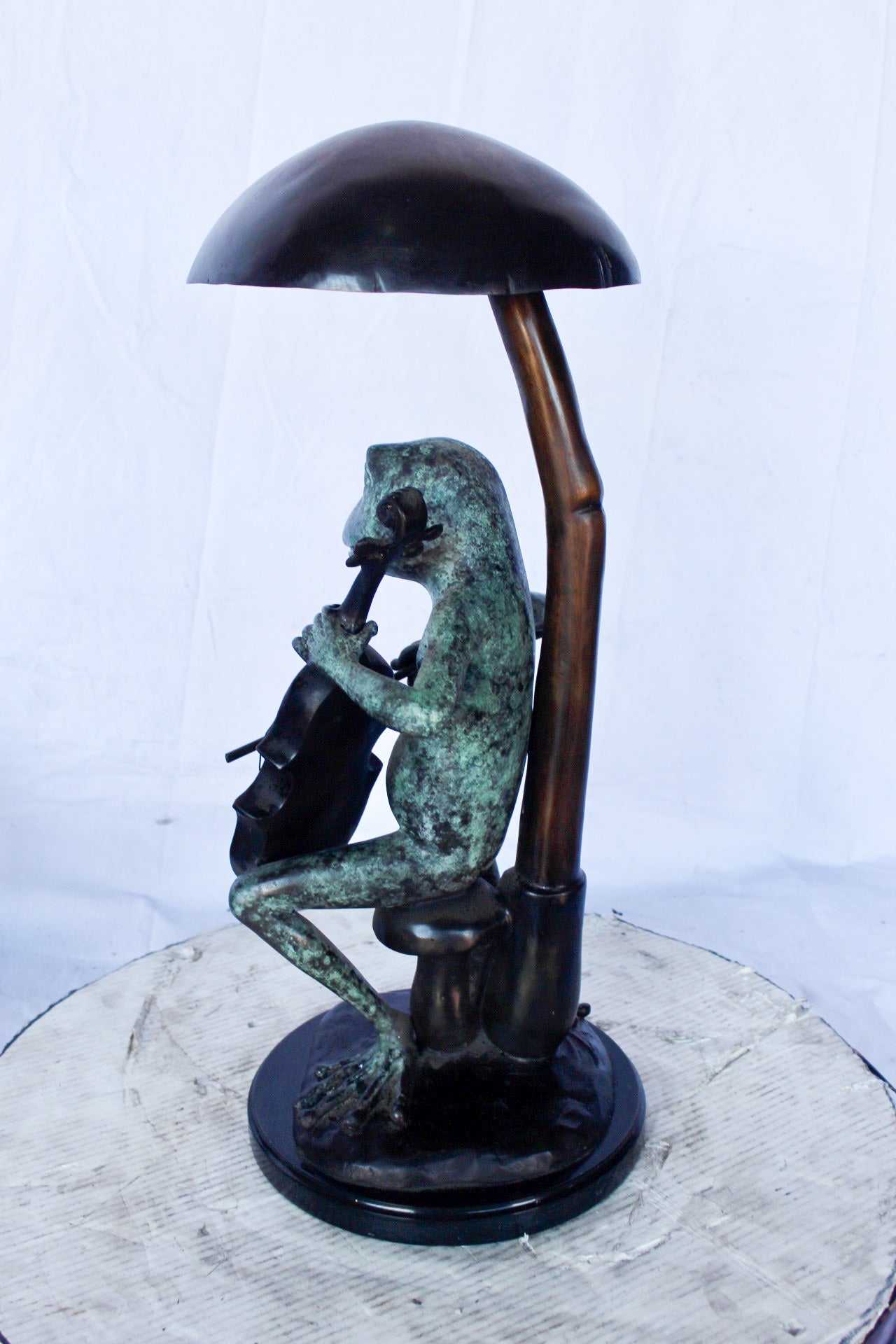 Frog playing cello under mushroom bronze statue - Size: 10"L x 10"W x 24"H.