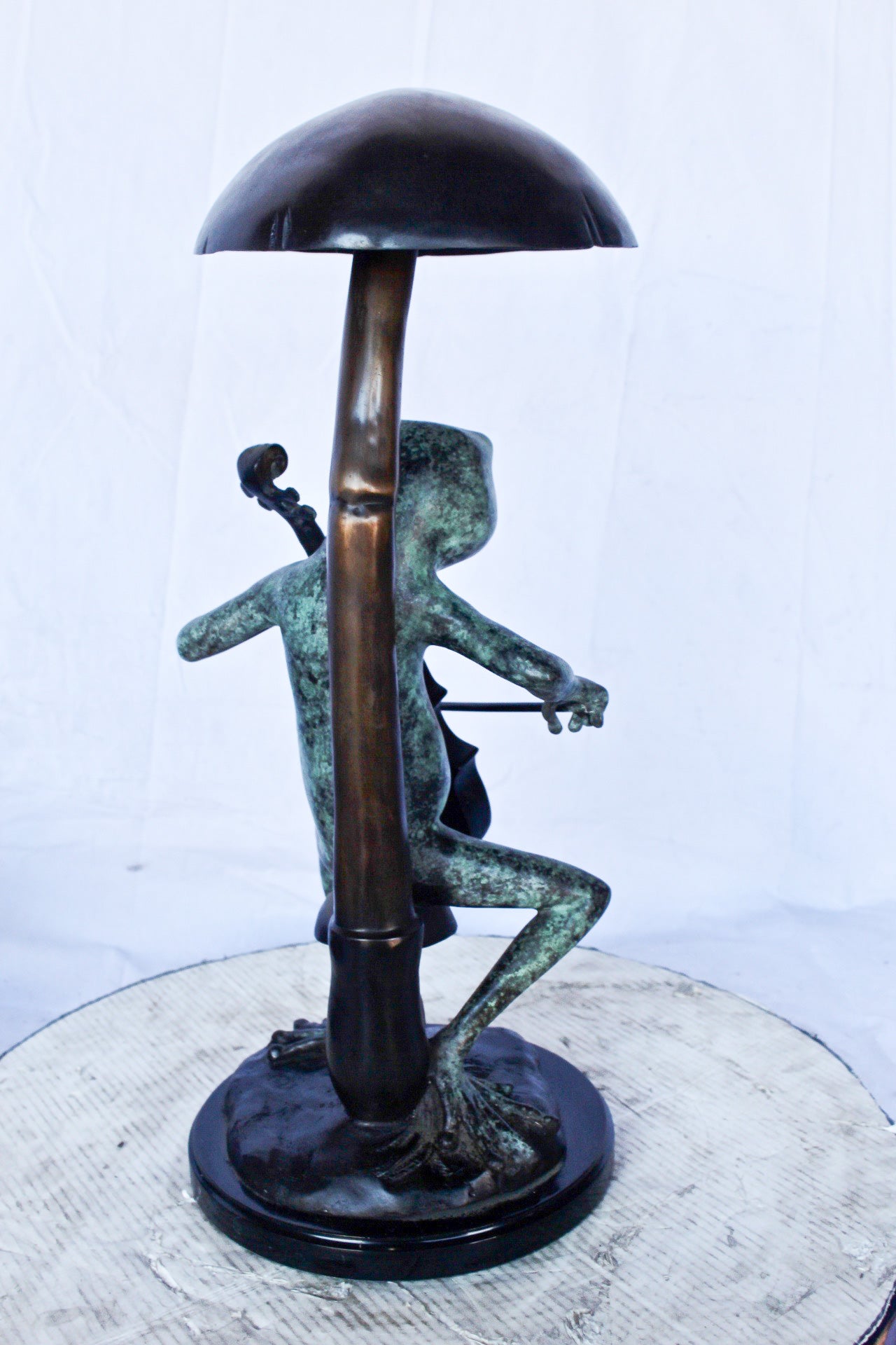 Frog playing cello under mushroom bronze statue - Size: 10"L x 10"W x 24"H.