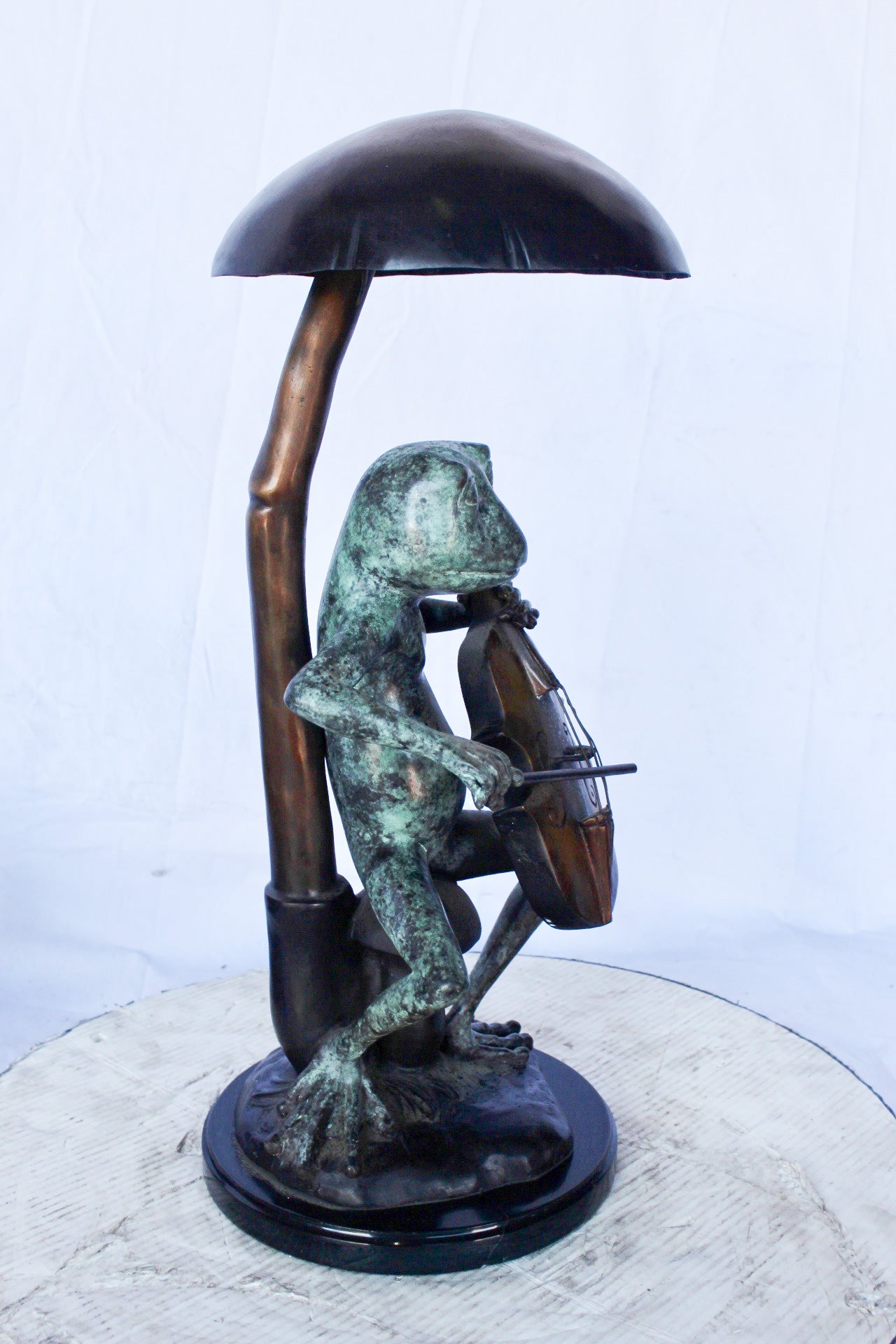 Frog playing cello under mushroom bronze statue - Size: 10"L x 10"W x 24"H.