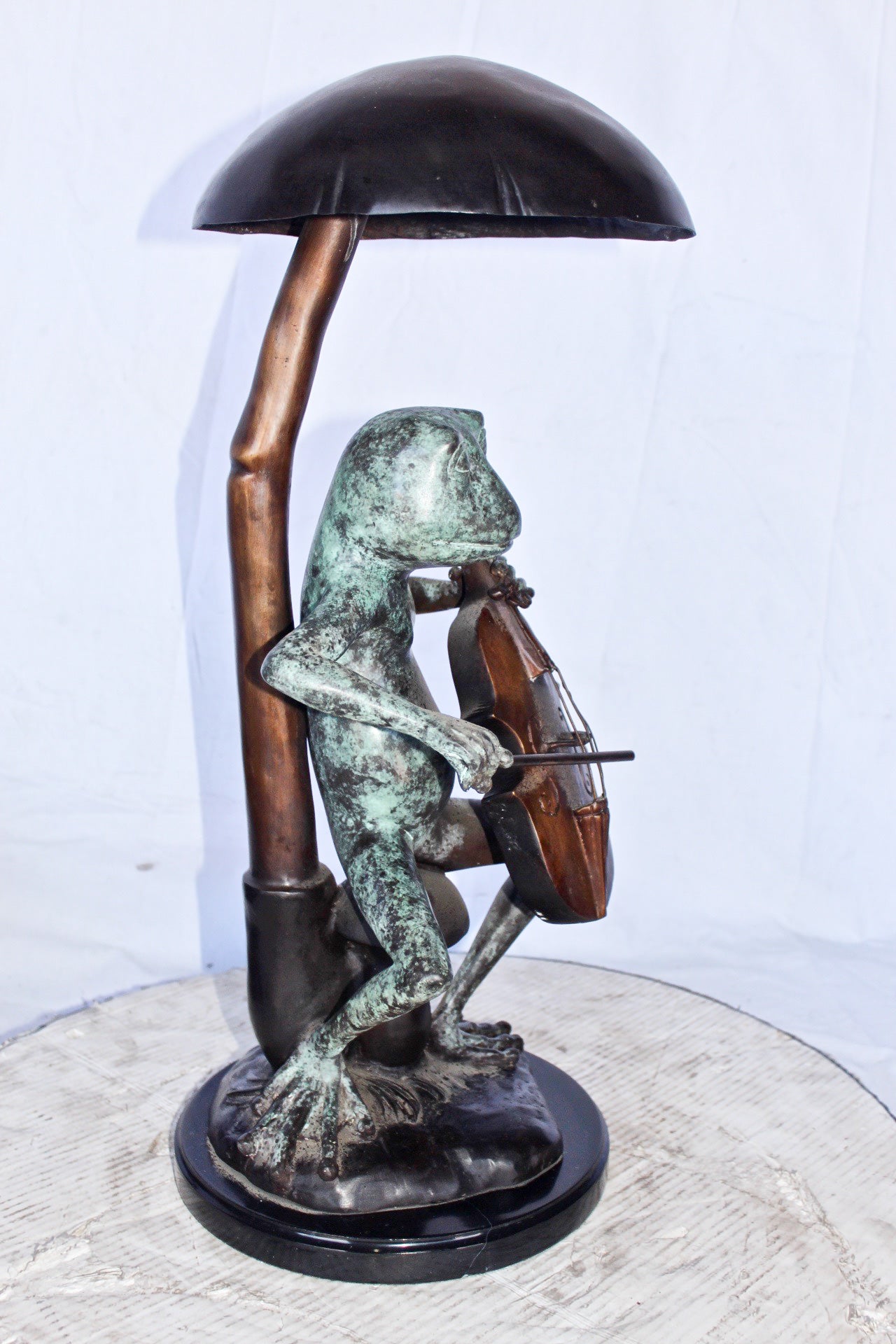 Frog playing cello under mushroom bronze statue - Size: 10"L x 10"W x 24"H.