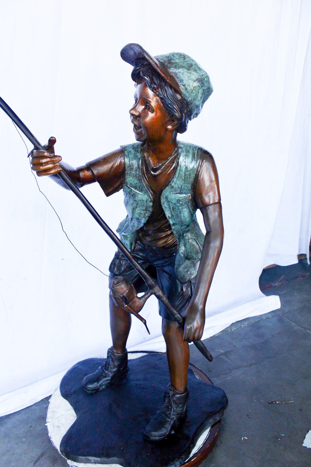 A young boy and his fishing journey bronze statue - Size: 24"L x 26"W x 47"H.
