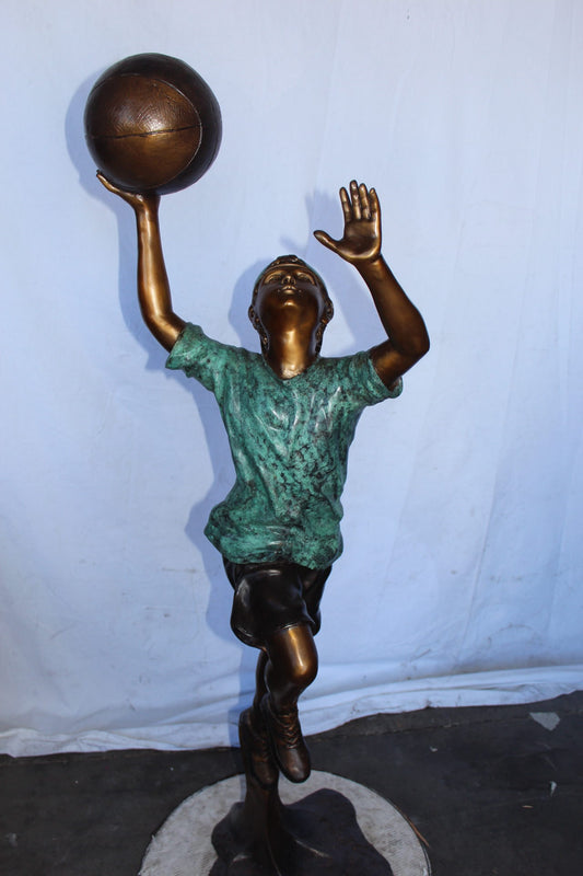 A young boy scoring a basket bronze statue - Size: 19"L x 20"W x 61"H.