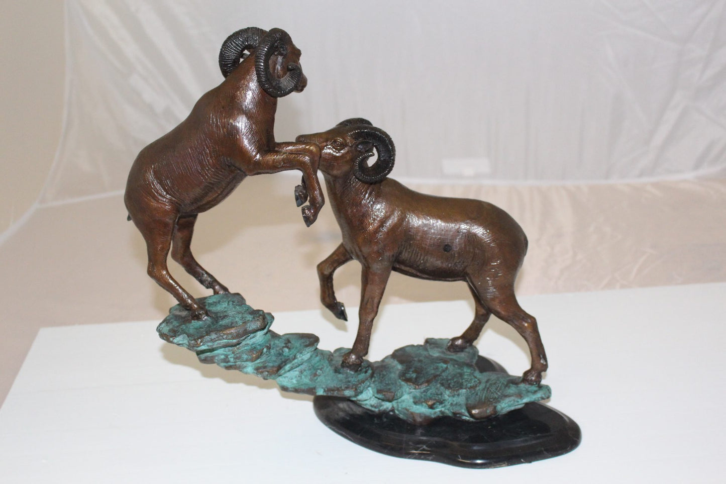 Two Rams on a rock Bronze Statue - Size: 15"L x 8"W x 16"H.