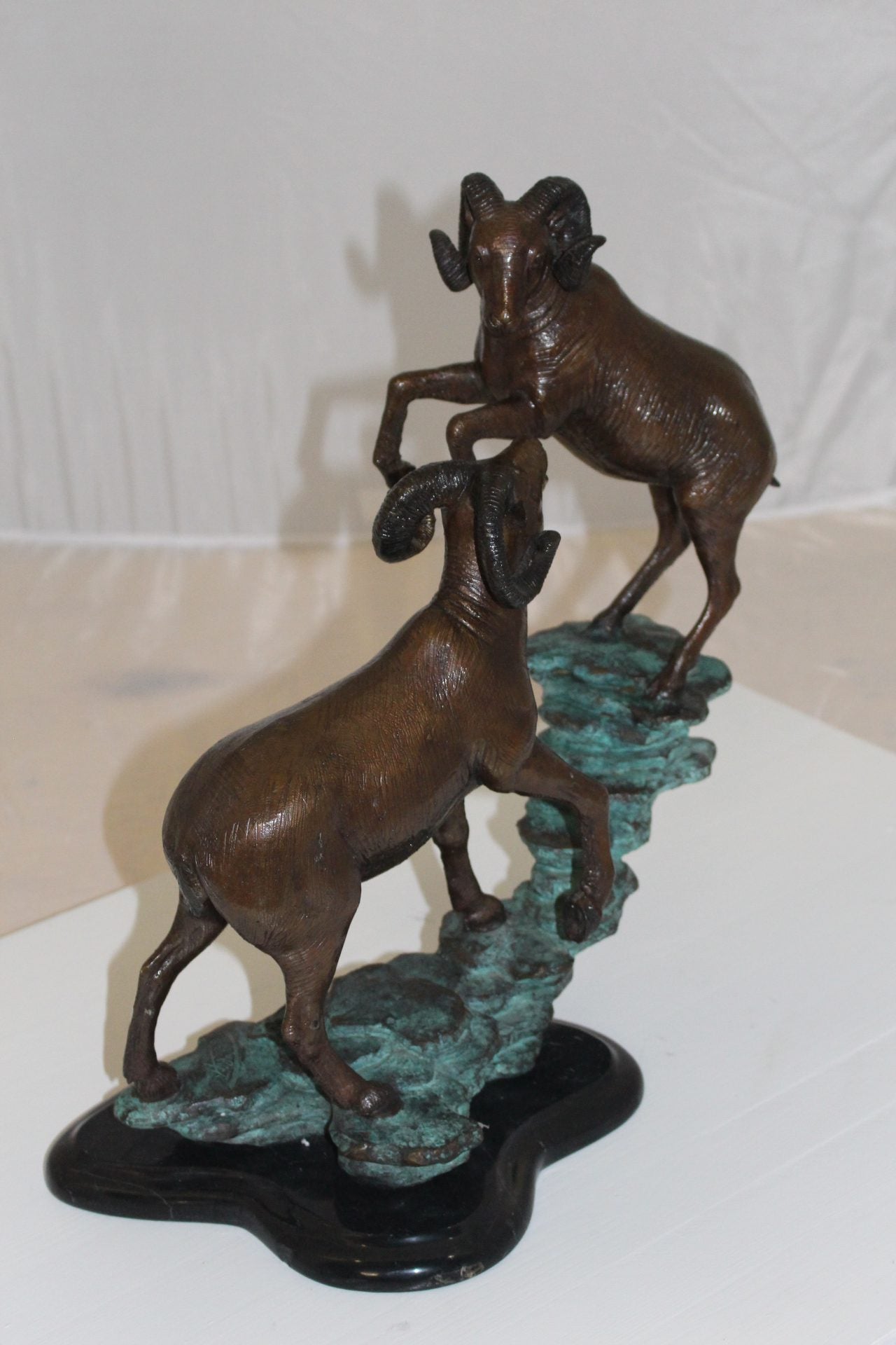 Two Rams on a rock Bronze Statue - Size: 15"L x 8"W x 16"H.