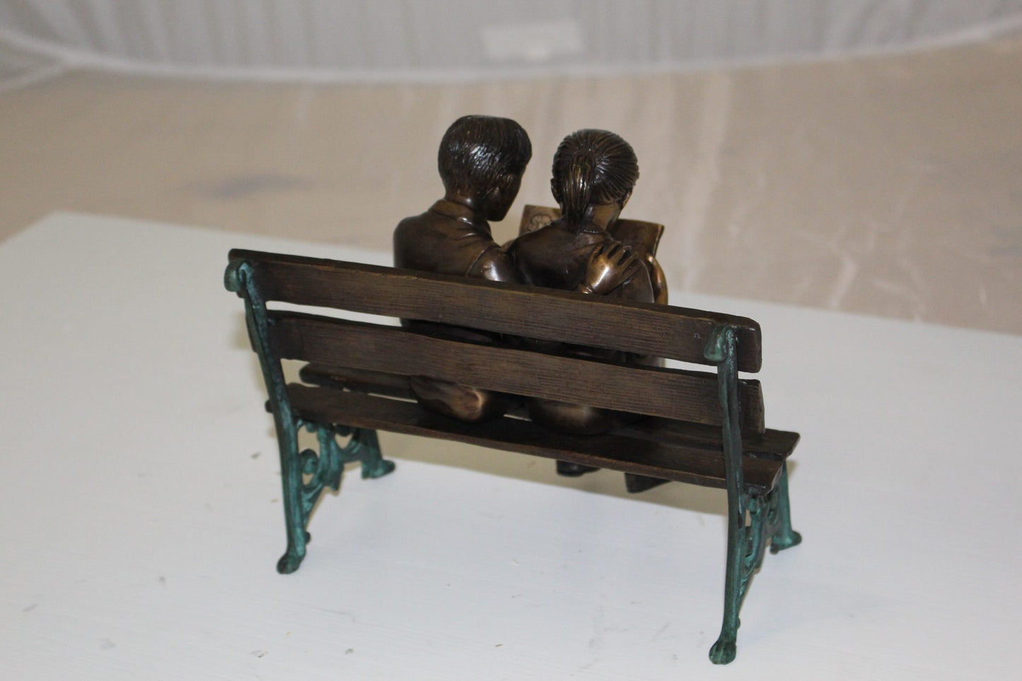 Two kids on bench reading a book - Bronze Statue - Size: 9"L x 6"W x 8"H.
