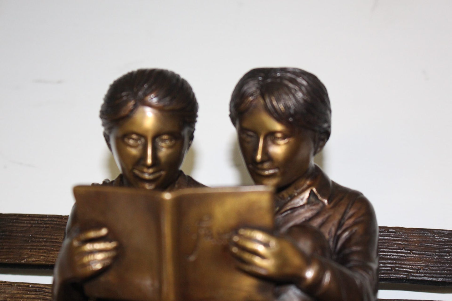 Two kids on bench reading a book - Bronze Statue - Size: 9"L x 6"W x 8"H.
