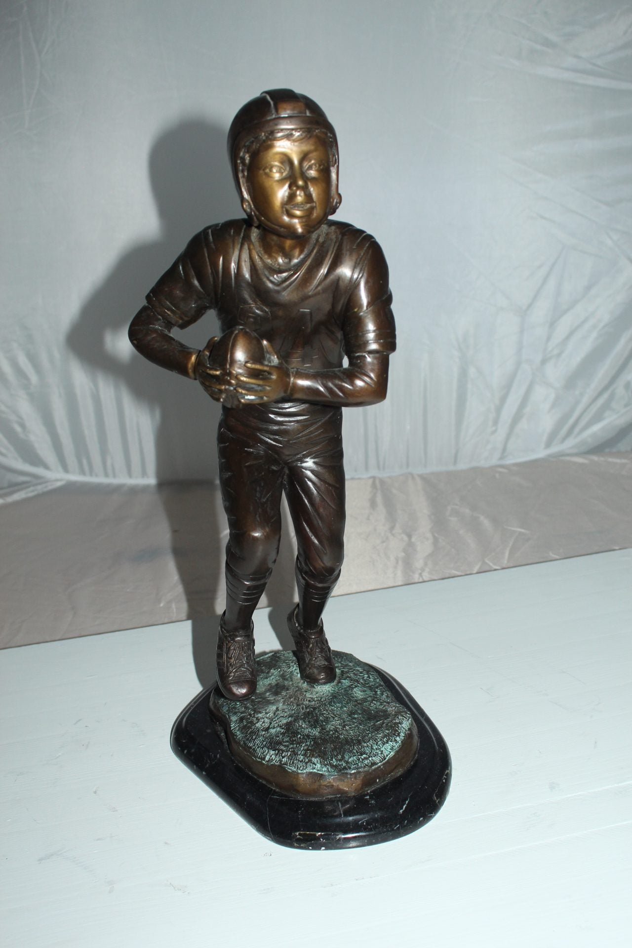 Boy playing football Bronze Statue - Size: 10"L x 8"W x 20"H.