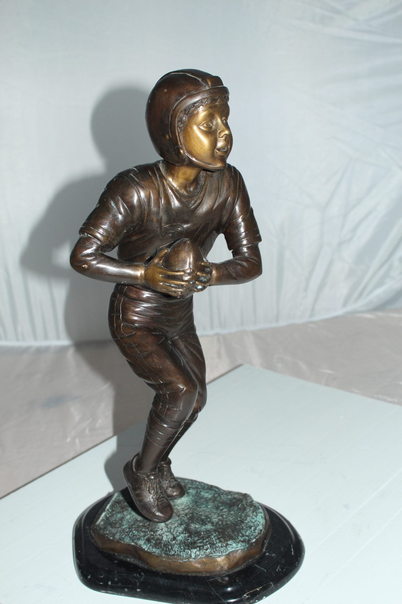 Boy playing football Bronze Statue - Size: 10"L x 8"W x 20"H.