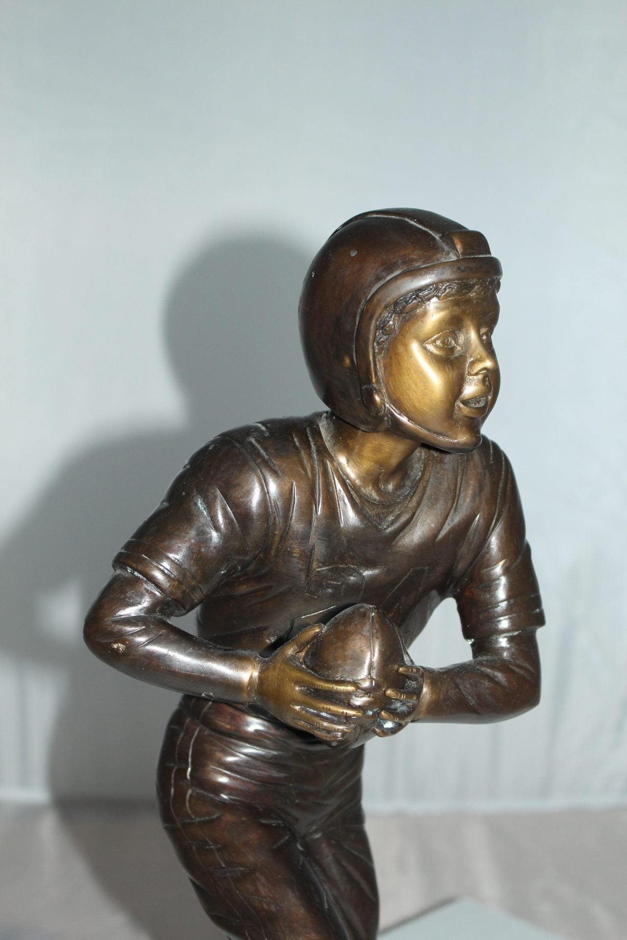 Boy playing football Bronze Statue - Size: 10"L x 8"W x 20"H.
