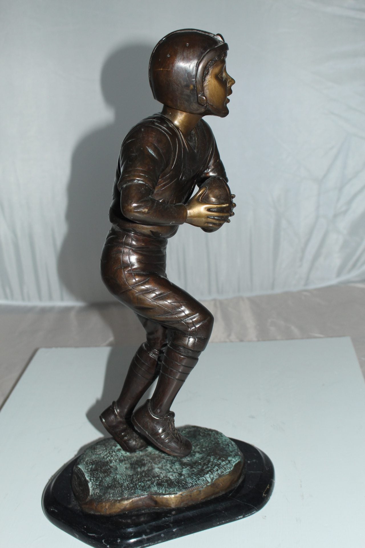 Boy playing football Bronze Statue - Size: 10"L x 8"W x 20"H.