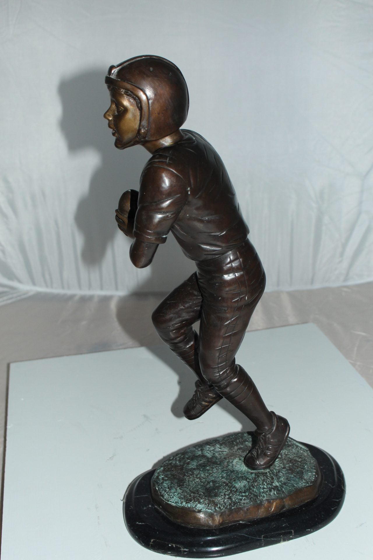 Boy playing football Bronze Statue - Size: 10"L x 8"W x 20"H.