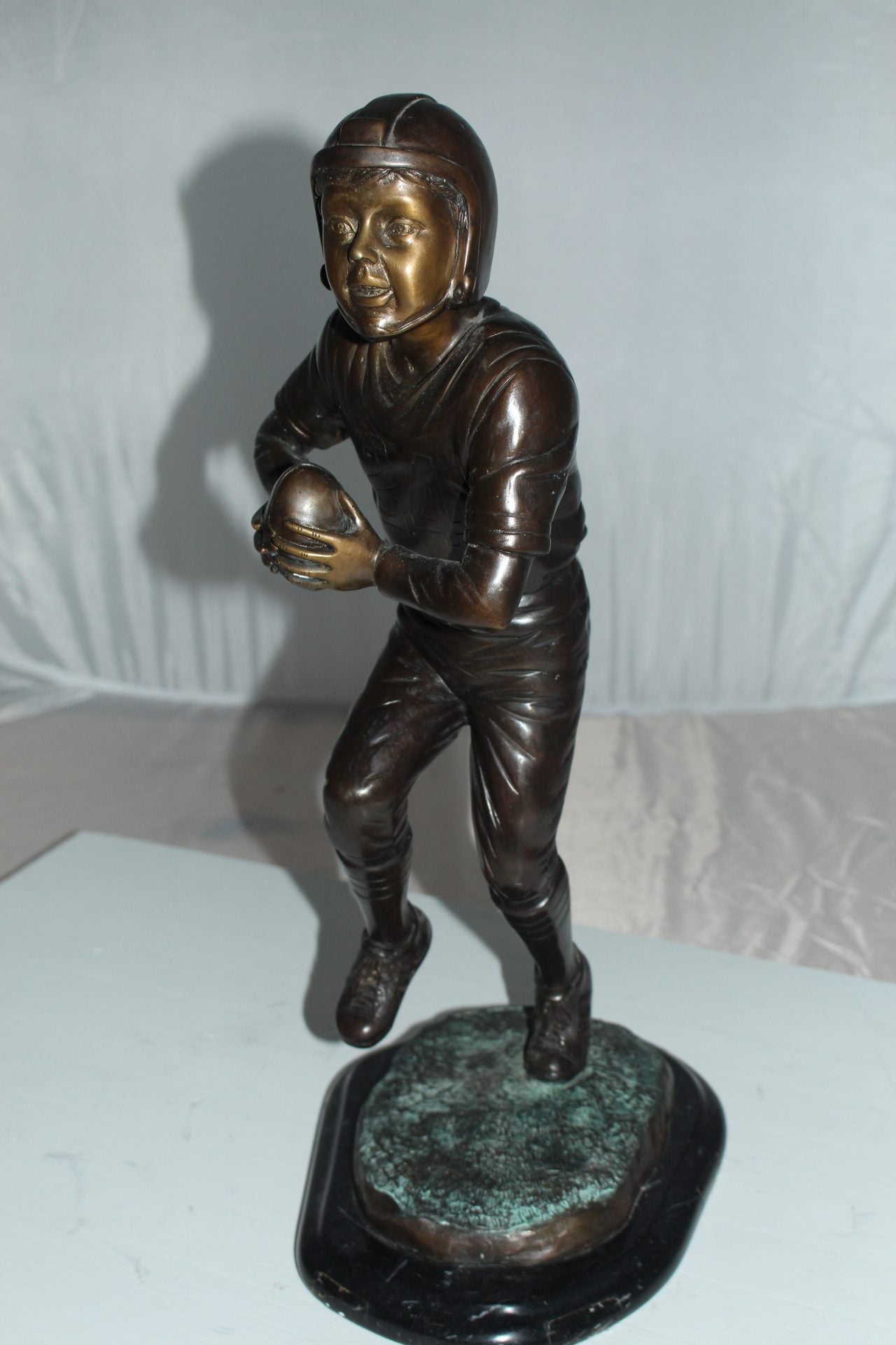 Boy playing football Bronze Statue - Size: 10"L x 8"W x 20"H.