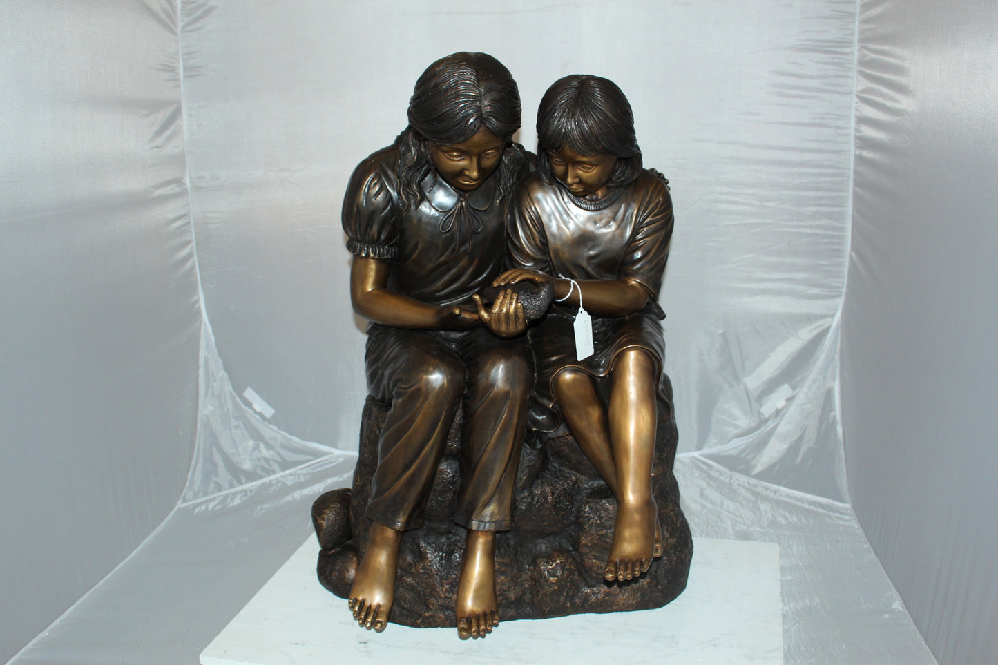 Two kids holding a bird Bronze Statue - Size: 18"L x 26"W x 34"H.